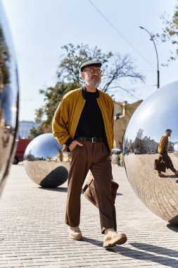Şık kıdemli adam şık moda anlayışını sergiliyor şehir manzarasında güvenle yürürken..