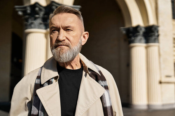 A senior man strolls confidently through an urban setting, showcasing his fashionable attire.