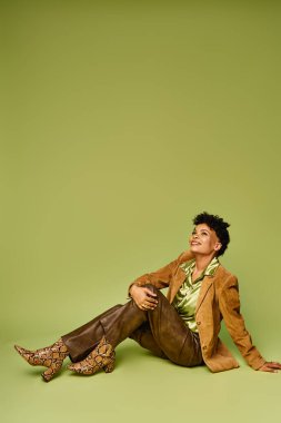 Zarif bir Afrikalı Amerikalı kadın zarif bir şekilde oturuyor, modern moda ve zarafeti sergiliyor..