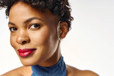 Güzel bir Afrikalı Amerikalı kadın modern modayı şık görünüşü ve kendine güvenen gülümsemesiyle somutlaştırıyor..