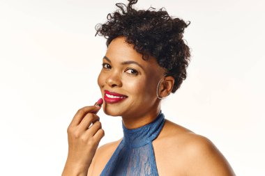 Zarif Afro-Amerikan kadını, kendine güvenini ve tarzını göstererek güzelliğini rujla arttırıyor..