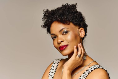 Zarif bir Afrikalı Amerikalı kadın zarif bir şekilde poz veriyor, kendine güveni olan şık bir görünüm sergiliyor..