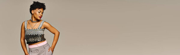 Элегантная афроамериканка демонстрирует свой стильный наряд в шикарной обстановке.