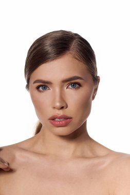 Şık bir çevrede zarif genç bir kadın çarpıcı gözlerle ve dengeli bir ifadeyle büyülüyor..