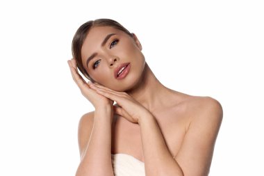 Zarifçe poz veren genç bir kadın. Elleri yüzünün yanında, zarafet ve cazibe saçıyor..