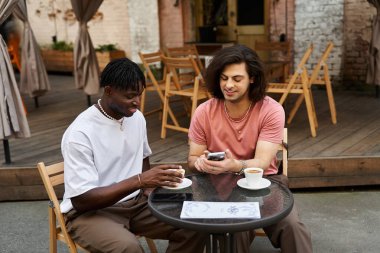 Two handsome men enjoy a joyful coffee moment together in a charming cafe. clipart