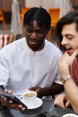 İki yakışıklı, kahve içerken gülüşlerini ve neşelerini paylaşıyorlar..