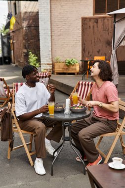 İki yakışıklı, neşe dolu bir kafede birlikte yemek yerken kahkaha ve lezzetli içkileri paylaşıyor..