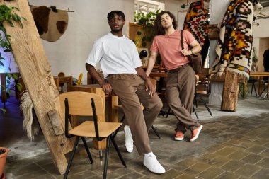 İki yakışıklı ortak, yeşil ve tarz ile çevrili, rahat bir kafede romantik bir anı paylaşıyor..