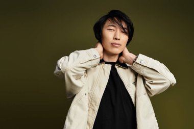 Genç bir Asyalı, bir stüdyoda zarif poz verirken moda tarzını sergiliyor..