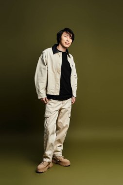 Genç bir Asyalı modern bir stüdyoda moda anlayışını şık bir kıyafetle sergiliyor..