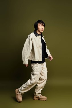 Genç bir Asyalı kendine güvenen, çağdaş moda eğilimlerini bir stüdyoda somutlaştırıyor..