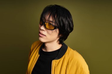 Kendine güvenen genç adam renkli bir arkaplana karşı modaya uygun pozlar veriyor..