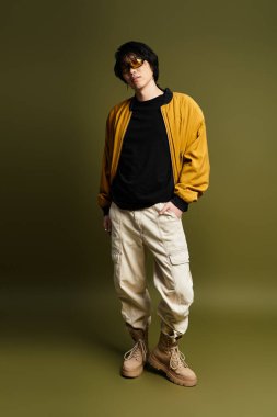 Genç Asyalı bir adam modern tarzını sergilemek için şık bir kıyafet giyiyor..