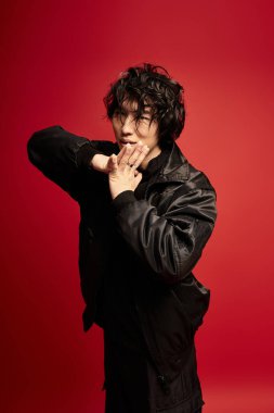 Genç Asyalı bir adam stüdyoda kendine güvenen bir poz veriyor..