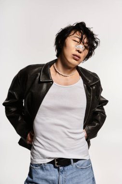 Deri ceketli ve burununda sıva olan Asyalı adam modern bir tarz sergiliyor..