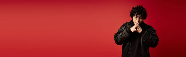 Trendy Asian man in studio, hands clasped, contemplative look, banner