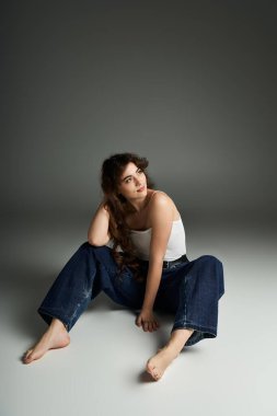 Şık giyinmiş genç, çekici bir kadın zarif bir poz veriyor, kendine güveni tam..