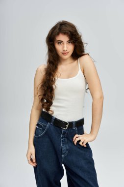 Güzel saçı olan genç bir kadın moda anlayışını canlı bir stüdyo ortamında sergiliyor..