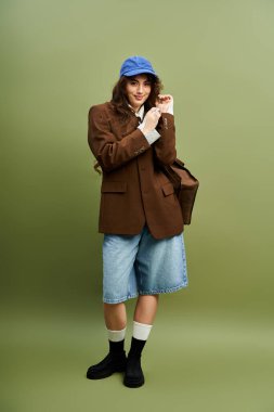 Çekici genç bayan kendine güvenerek şık bir elbise içinde poz veriyor. Spor ceket ve kot şort giyiyor..