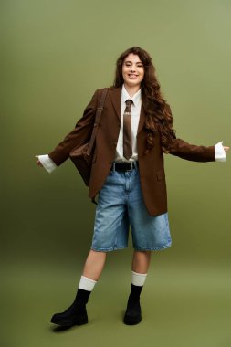 Hayat dolu genç bir kadın şık bir kıyafet ve moda aksesuarlarla benzersiz tarzını sergiliyor..