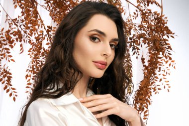 Dalgalı kahverengi saçlı hoş bir genç kadın canlı bir bahar gününün tadını çıkarıyor.