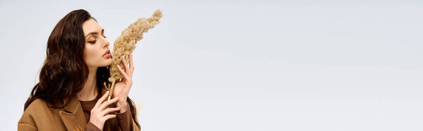 Молодая женщина с прекрасными длинными каштановыми волосами наслаждается весной в своем уютном пальто, баннер