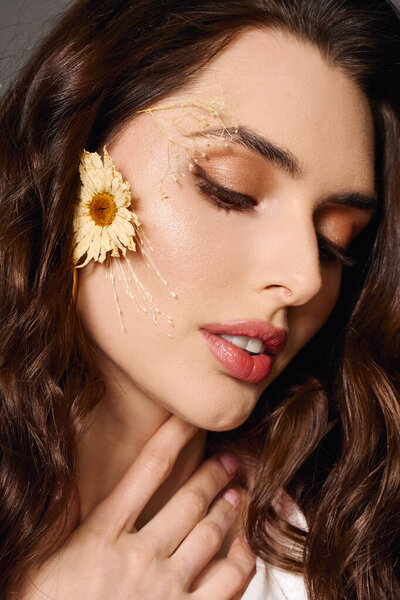 Молодая женщина с каштановыми волосами нежно взаимодействует с весенними цветами, олицетворяя красоту природы.