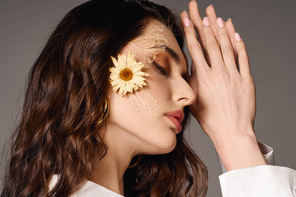 Красивая молодая женщина с каштановыми волосами нежно кладет голову, украшенную весенними цветами.