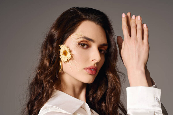 Прекрасная молодая женщина с каштановыми волосами позирует среди красочных весенних цветов.