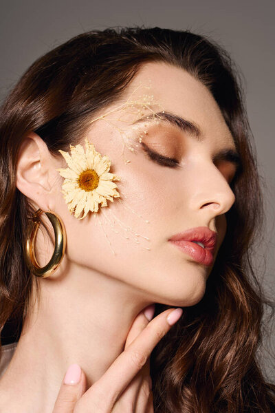 Молодая женщина с каштановыми волосами, украшенная цветком, излучает спокойствие среди весенних цветов..