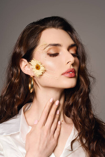 Красивая молодая женщина с каштановыми волосами касается шеи, элегантно украшенной цветами.