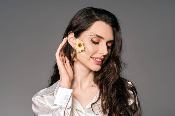 Красивая молодая женщина с каштановыми волосами демонстрирует свою радость в окружении восхитительных весенних цветов.