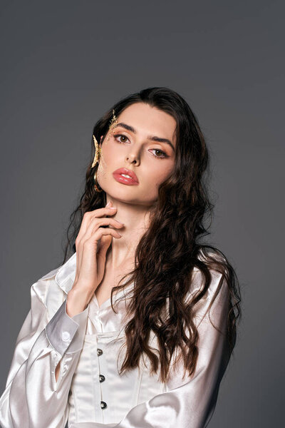 Красивая молодая женщина с каштановыми волосами изящно позирует с весенними цветами.