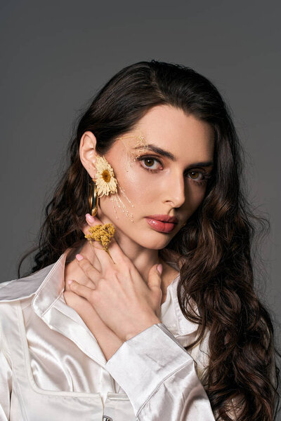 Молодая женщина украшает свою красоту цветами, окруженная яркими весенними цветами.