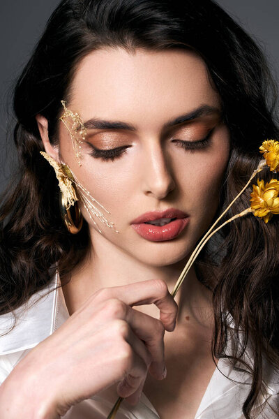 Красивая молодая женщина с каштановыми волосами изящно взаимодействует с цветущими цветами весной