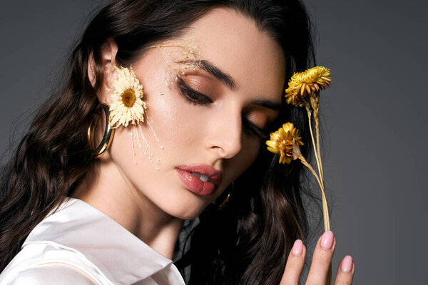 Молодая женщина с каштановыми волосами восхищается весенними цветами, демонстрируя свою природную красоту.