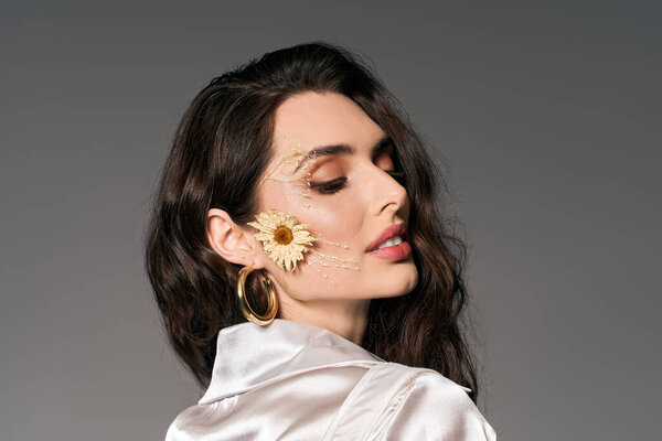 Молодая женщина с каштановыми волосами наслаждается яркой красотой весны в то время как среди красочных цветов.