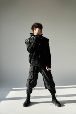 Modaya uygun genç Asyalı adam, modern ve parlak bir mekanda dururken eşsiz tarzını sergiliyor..