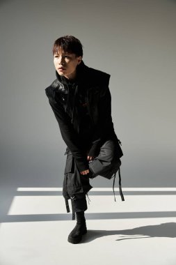 Şık bir Asyalı genç adam şık bir şehir zeminine karşı poz veriyor..