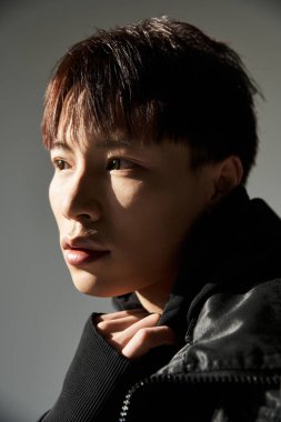 Parlak bir ışık şık giyinmiş yakışıklı bir genci vurgular, sanatsal bir hava yaratır..