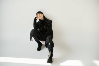 Şık bir genç adam duvara yaslanır, güven ve rahatlama yayar..