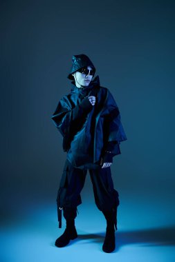 Yakışıklı Asyalı genç adam siyah bir elbisenin içinde cesur detaylarla benzersiz bir tarz sergiliyor..