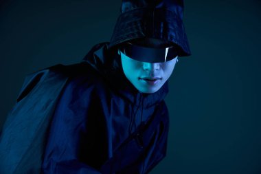 Yakışıklı Asyalı adam güneş gözlüğü ve loş ışık altında gösteriş yapıyor..