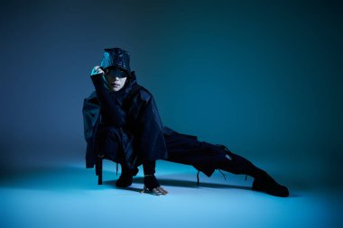 Şık bir Asyalı, dramatik bir ortamda eşsiz bir poz verir..