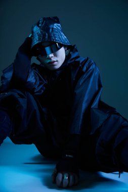 Siyah elbiseli yakışıklı bir Asyalı şık bir pozla kendine güvenen bir poz veriyor..