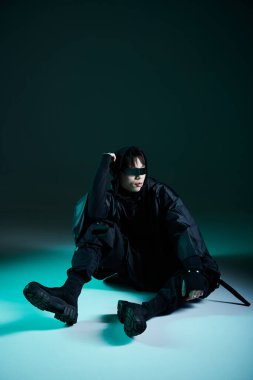 Yakışıklı genç bir adam şık kıyafetini sergiliyor, çağdaş bir ortamda güvenle poz veriyor..