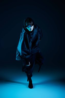 Şık bir genç adam çarpıcı bir mavi arkaplan karşısında kendine güveniyor..