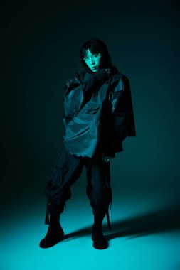 Yakışıklı Asyalı adam havalı ışıklandırmada artistik bir poz verirken moda yaratıyor.