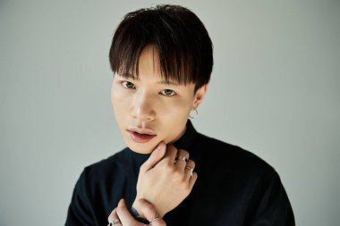 Modern moda ve aksesuarlarda, derin düşüncelere dalmış kendinden emin genç bir adam..